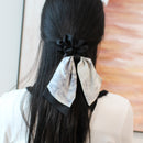 Green and pink bow hair ties stacked together showing color contrast