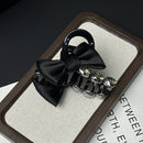 Side angle of crystal-embellished bow claw clip showing smooth matte finish and satin ribbon texture