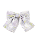 Oversized satin bow hair clip in soft pink on white background, front view