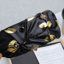 Ruched fabric texture and stitching detail on emerald green headband