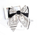 Black and white cashew accessories displayed together on folded linen