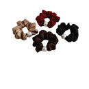 Front view of four pearl-accented hair ties on white background