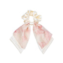 Flat lay of pink bow hair tie with dried lavender and notebook