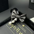 Model wearing black bow claw clip at crown with loose shoulder-length hair