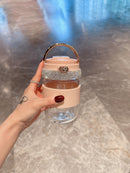 Green tumbler on wooden kitchen counter with fresh fruit and herbs