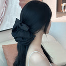 Side angle showing layered fabric bow and sturdy metal shark clip mechanism