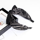 White cashew scrunchie stretched to show elasticity and recovery